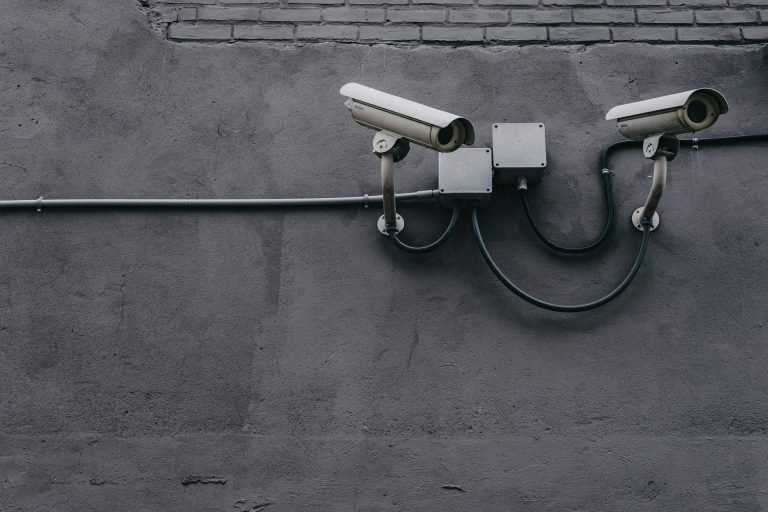 Dos cámaras de videovigilancia tipo bullet instaladas en la fachada de un edificio