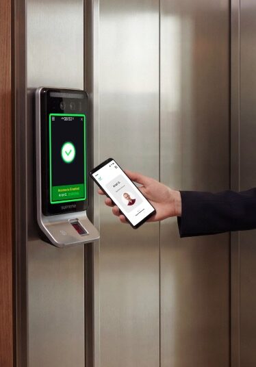 Persona acercando el teléfono a un terminal Suprema